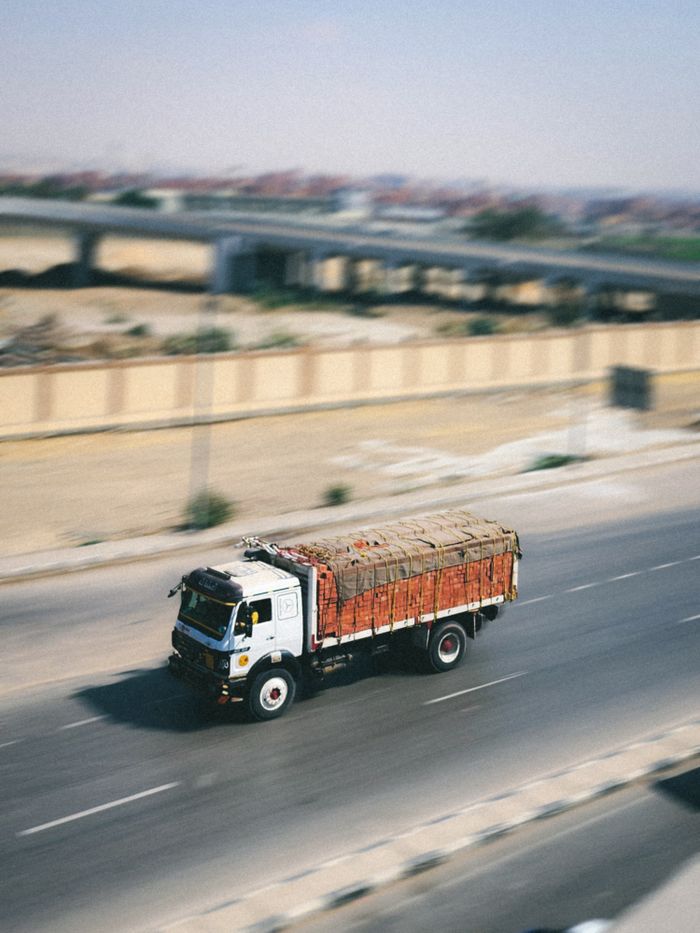 A cargo truck swiftly travels on a highway, emphasizing logistics and speed.